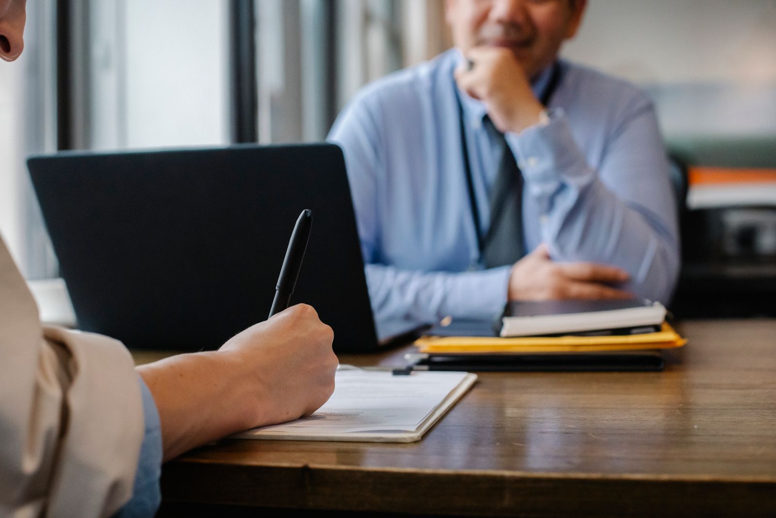A lawyer taking notes during a consultation with a client